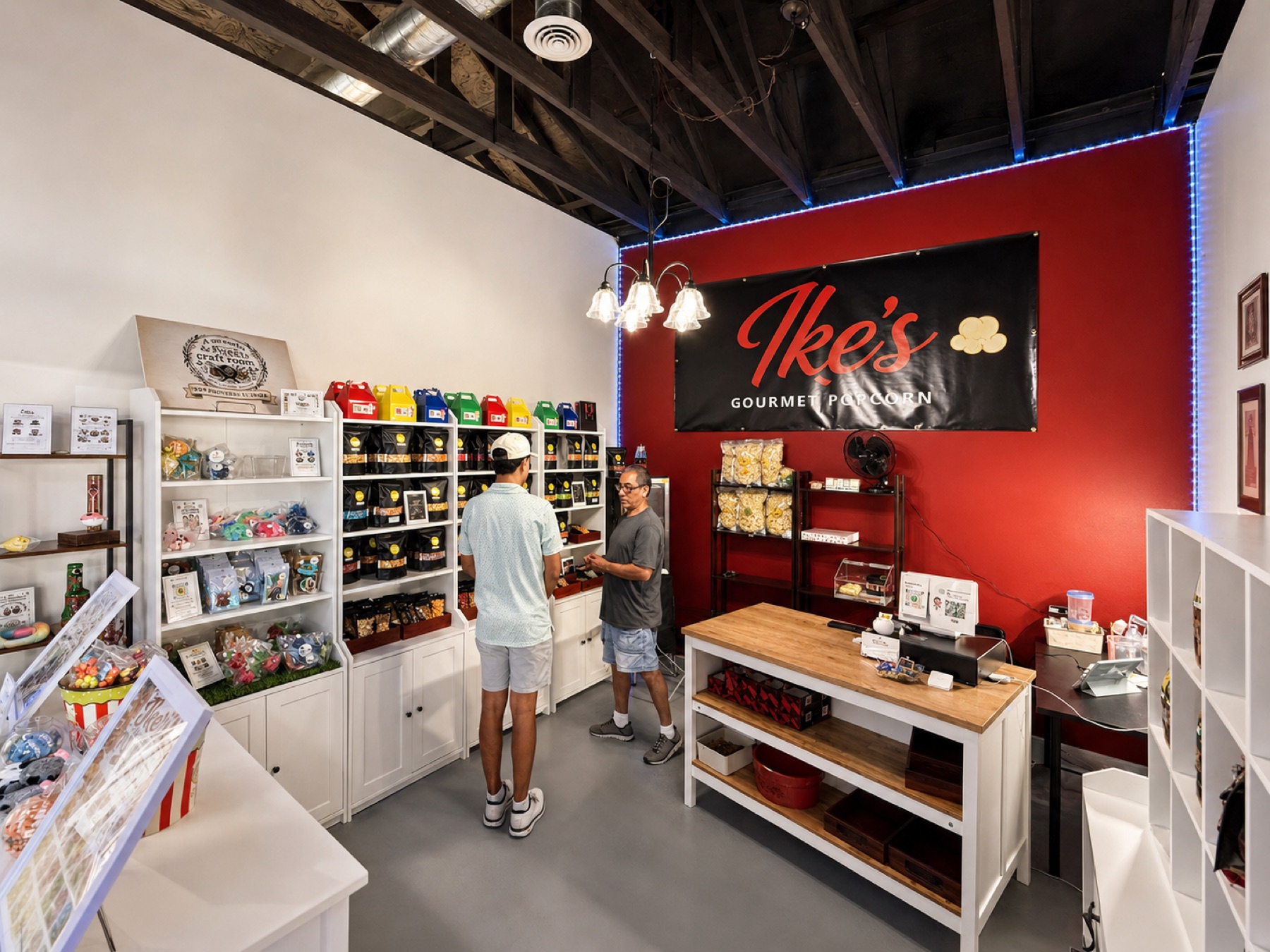 Ike's Gourmet Popcorn storefront inside Wells Market in Weslaco, TX, with red feature wall and shelves of flavored popcorn